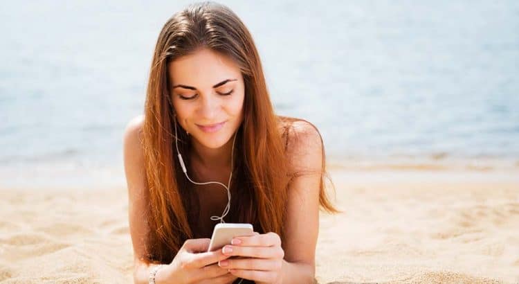Девушка с телефоном на пляже