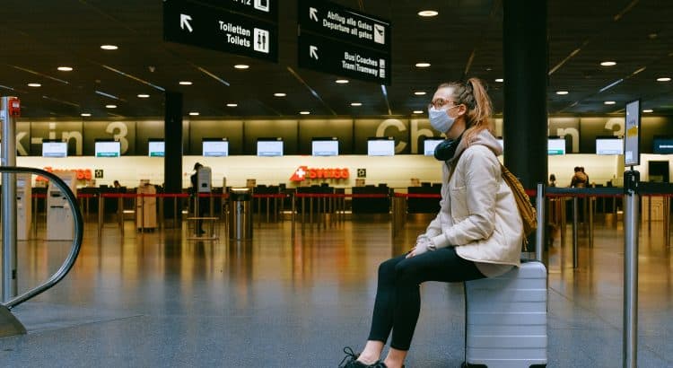 Турист в маске в ожидании рейса в аэропорту